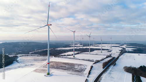 Windless wind turbine in snow, dark doldrums or wind lull in winter, renewable sustainable energy, environmental conversation, Germany