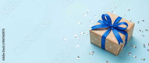 Wallpaper Mural Close up wide photo of beautiful gift box wrapped in kraft paper blue isolated light pastel color background with silver confetti empty blank copy space Torontodigital.ca