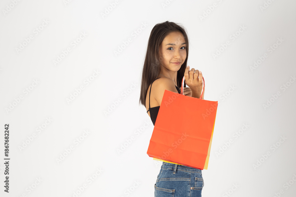 Fototapeta premium Girl holding a shopping bag and looking over her shoulder.
