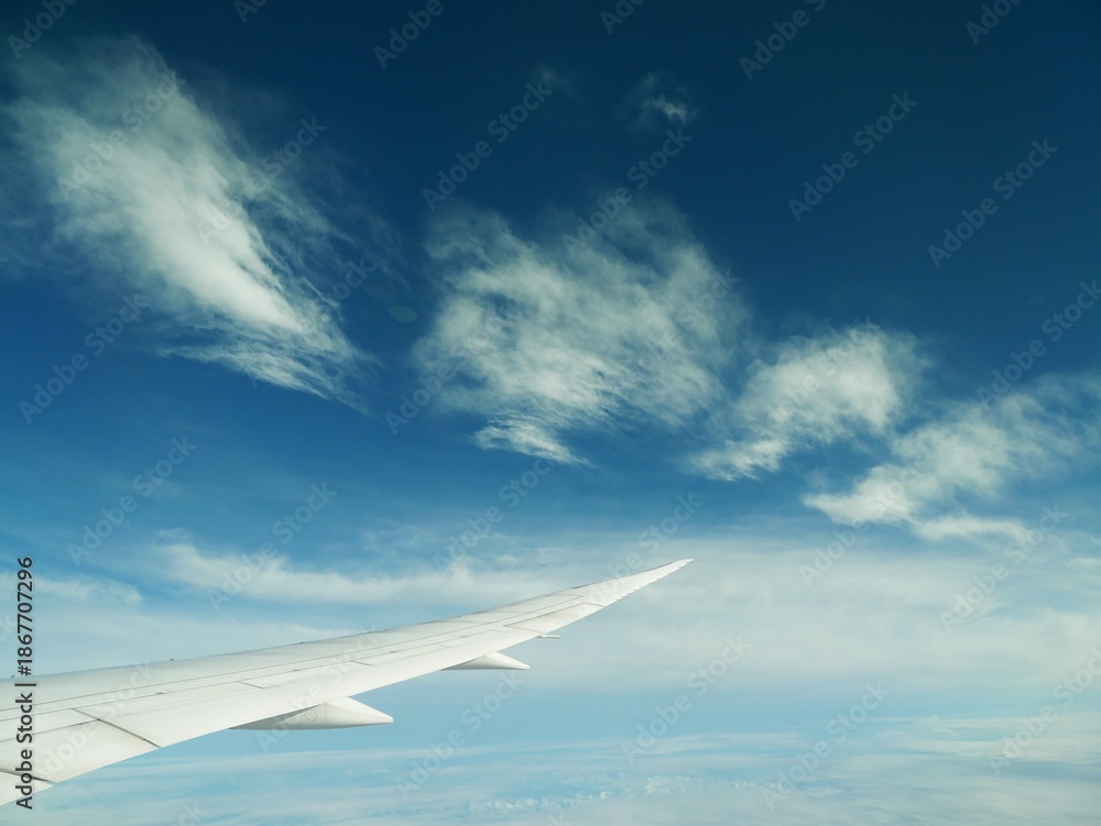 Fototapeta premium Airplane Wing Above Summer Clouds During Transpacific Flight