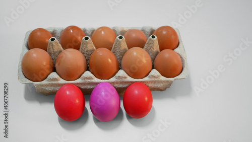 Red Dyed Easter Eggs and Natural Eggs in Carton