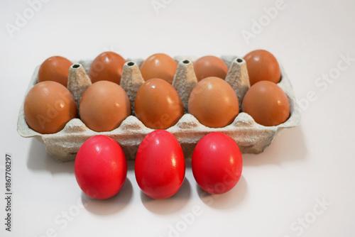 Red Dyed Easter Eggs and Natural Eggs in Carton