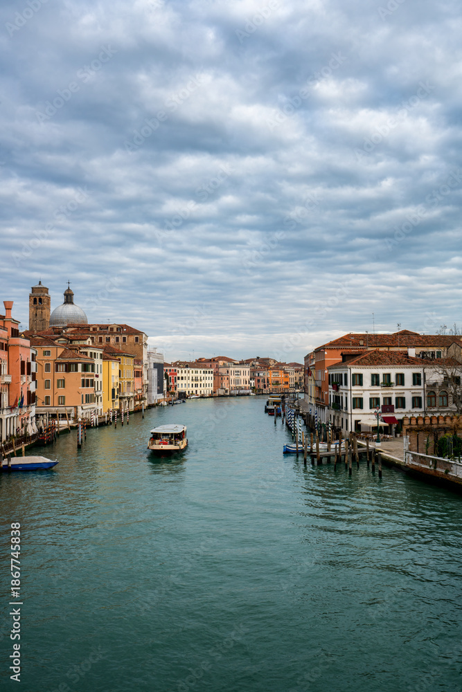 Obraz premium Characteristic historic buildings and a vaporetto navigating the