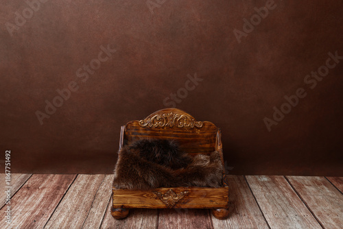 Brown monotone photograph of wood baby bed with fur for use as digital background or backdrop in fine art composite newborn photography for bum up or other pose using prop