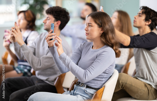 Fotografija Youth take pictures of projector screen presentation slides during lecture