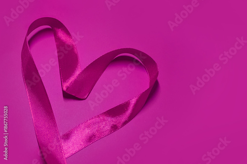 Pink Heart made of pink satin ribbon on Magenta background with space for text. Valentine's Day background. Valentine's Day concept.