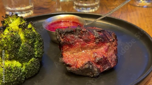 barbecue steak and broccoli Grilled pork steak with broccoli and tomatoes on plate, dark background.