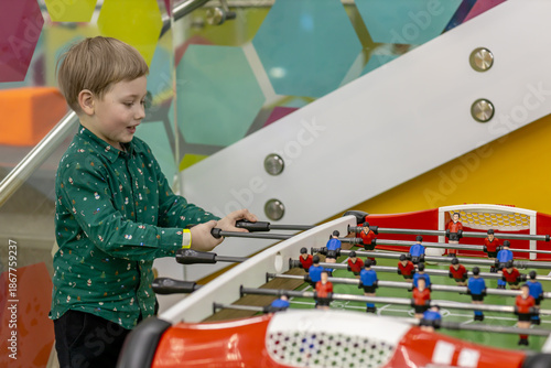 Boy playing table football in kids play area