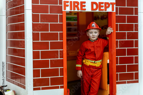 Boy in firefighter costume in indoor playroom
