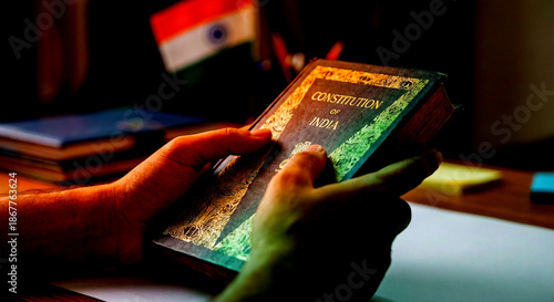 Hands holding the Constitution of India with Indian flag in background