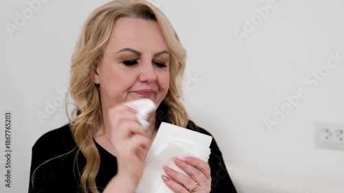 Woman blowing nose Woman blowing her nose in the room Woman, tissue and blowing nose. Female person, sick and sofa in home for bacteria problem in lounge with fatigue, sinus or influenza