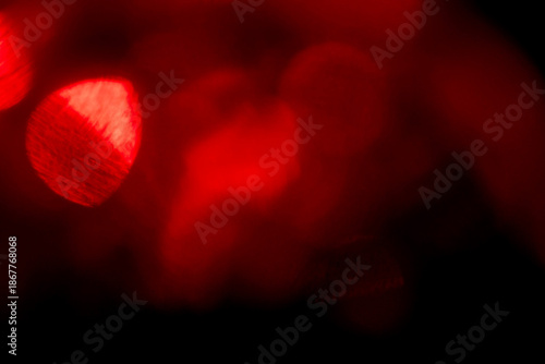 A blurry red image with a red light in the center. The light is surrounded by red and orange colors. Abstract light leaks for design and special effects.