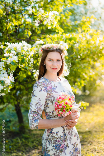Portrait of beautiful woman in blooming bush with white flowers