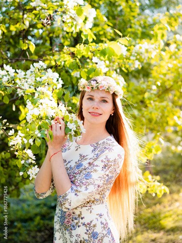 Portrait of beautiful woman in blooming bush with white flowers