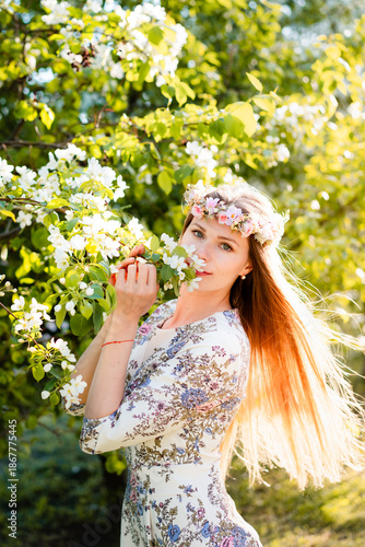 Portrait of beautiful woman in blooming bush with white flowers