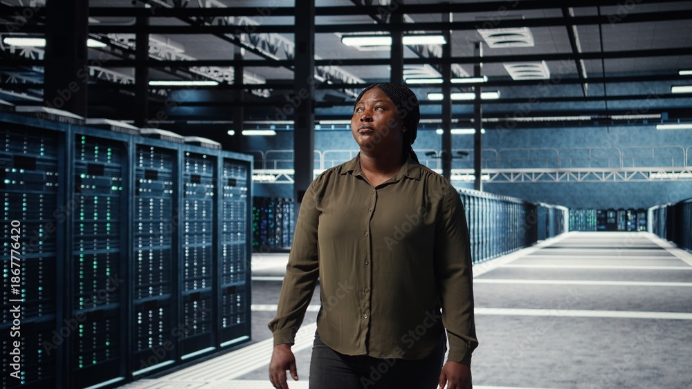 Fototapeta premium Portrait of cheerful data center engineer conducting security audits to protect against cyber threats. Jolly worker walking in server room, ensuring compliance with industry standards, camera A