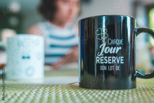 Close-up of a coffee cup with a cheerful phrase in French