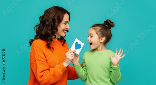 Woman giving heart card to excited girl with joyful reaction and bright colors