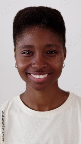 Vertical HD Portrait of young millennial black woman smiling at camera sitting at workplace