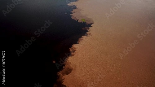 meeting of waters with a boat crossing the two rivers, Solimoes and Rio Negro in amazon brazil. High quality 4k footage