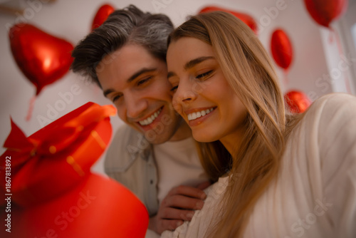 Close up of joyful young couple with red heart gift box on Valentine's Day celebration