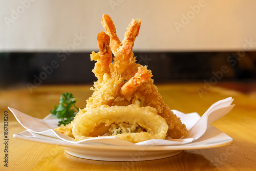 Tempura battered shrimp on a plate with a single squid ring