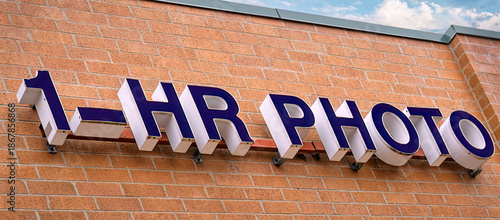 One hour photo sign on a brick building.