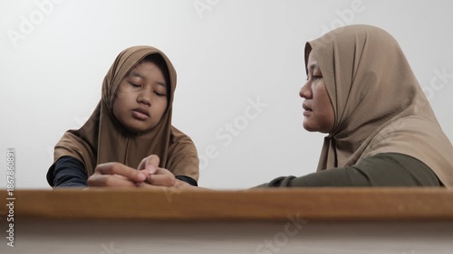 Muslim mother providing emotional support to her upset teenage daughter