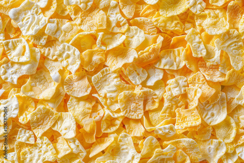 Cornflakes are showcased in a top view, emphasizing their texture and shape against a plain background.