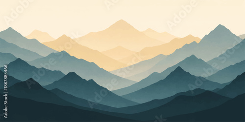 Misty blue mountain range at sunrise with fog and clouds settled in the valley between peak silhouettes under a clear morning sky