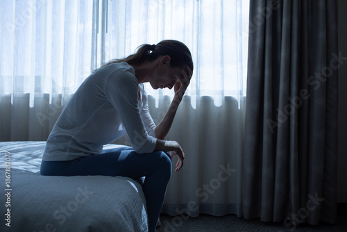 Exhausted  woman in a dark room with head down, Portrait of thoughtful sad female alone. prayer, fear, sadness, abuse, depression, addiction.