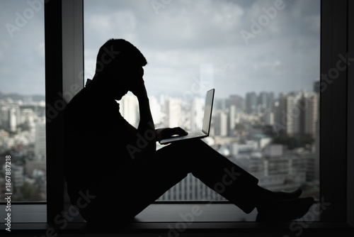 Canvastavla Exhausted stressed man on computer in a dark room with head down, Portrait of thoughtful sad male alone