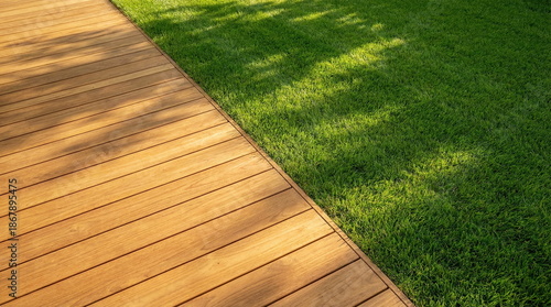 Modern wooden deck and lush green lawn bathed in sunlight, perfect for outdoor living, garden design, and natural backgrounds.