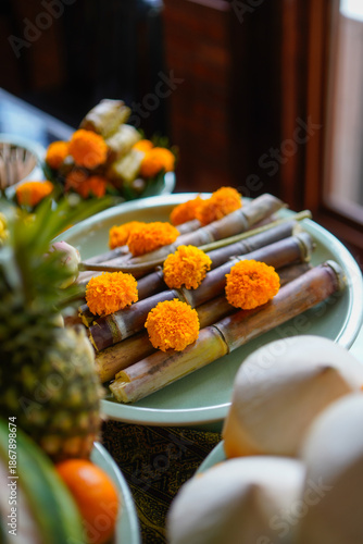 Traditional Thai offerings of sugarcane, marigolds, and sacred fruits for religious ceremony