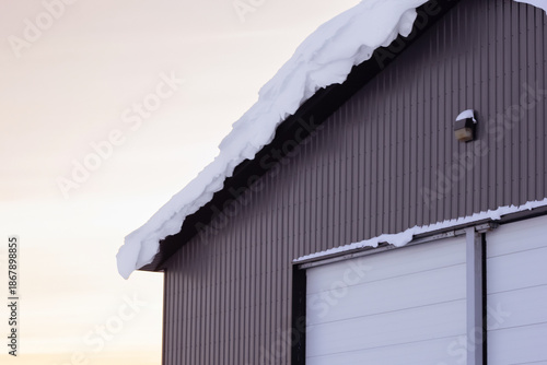 Warehouse in snow, industrial building in sunset light in winter.