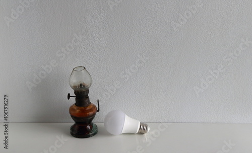 This image juxtaposes two different eras of lighting technology: a vintage-style kerosene lamp and a modern LED light bulb, highlighting the contrast between historical and current lighting method.