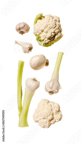 Assorted raw vegetables on black background, including cauliflower, garlic, and mushroom