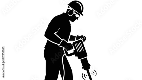 Construction worker operating jackhammer on site with safety gear