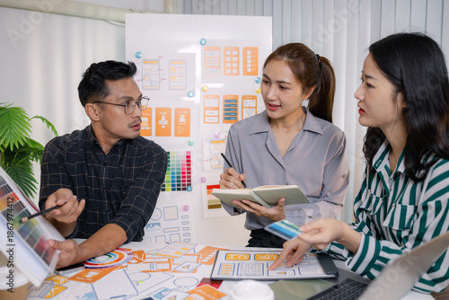Photos UX/UI designers presenting their final design project to the team, showcasing app interface screens and explaining user experience strategies in a professional creative office environment