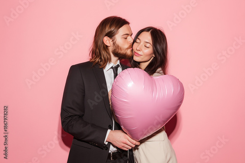 Couple in love holding pink heart shaped balloon on valentines day
