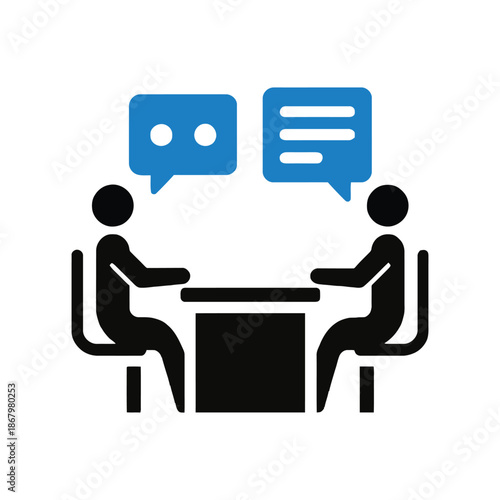 Two people sitting at a table talking to each other