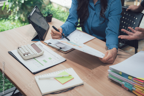 Canvastavla Analyzing Finance on Desk: Focused examination of a financial document, amidst office essentials, showcasing the diligence and attention to detail required in professional analysis