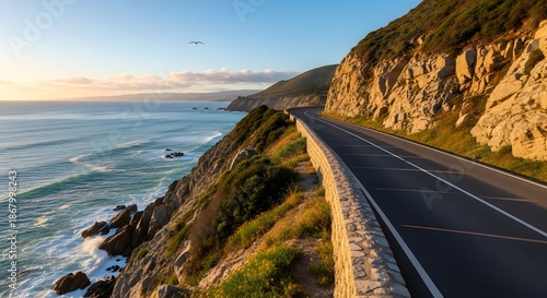 Coastal road winding along rocky cliffs with ocean views at sunrise