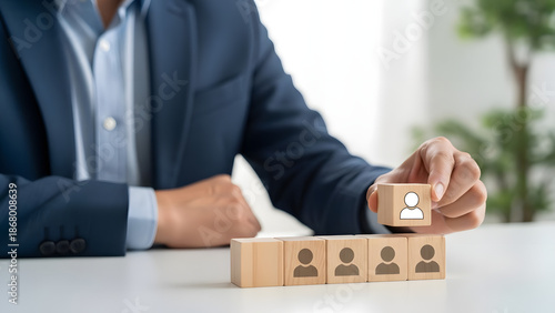 Professional hand placing a wooden block, symbolizing candidate selection and talent acquisition in human resources and team building strategy
