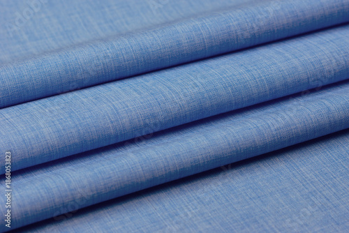 Plain blue fabric folded into folds. Close-up of the sewing fabric.