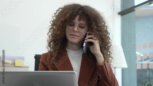 Focused professional woman working on laptop at modern office desk, analyzing business data charts,representing productivity, concentration,corporate workflow, remote work, digital finance, planning