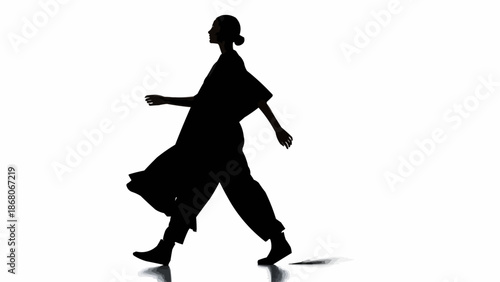 Silhouette of a woman walking forward with flowing clothes.