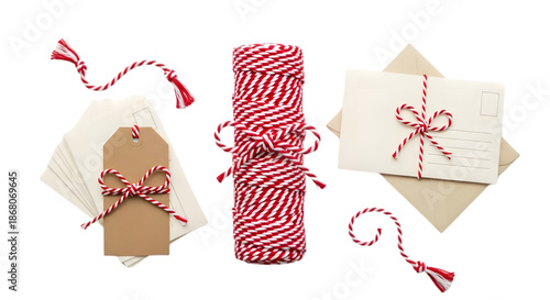 A roll of red and white striped ribbon png alongside envelopes and gift tags adorned with red bows on a white background