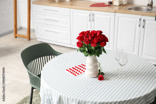 Vase with red roses on dini...