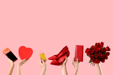 Female hands with payment terminal, credit card, wallet and gifts on pink background. Valentine's Day celebration